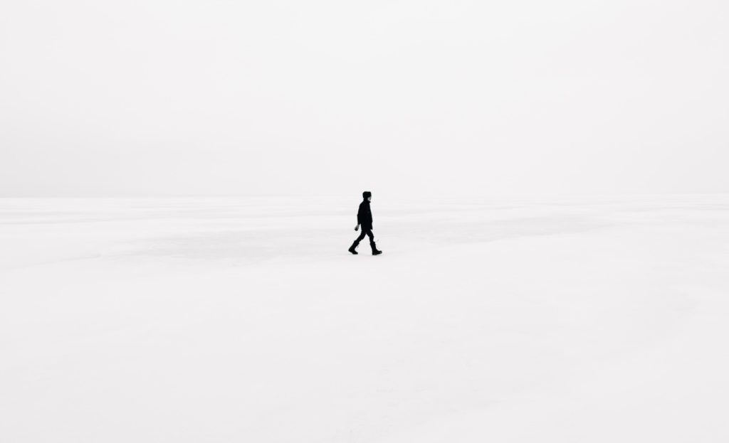 a man walking through the snow  in black and white