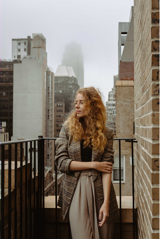 A girls standing on balcony and looking down the street