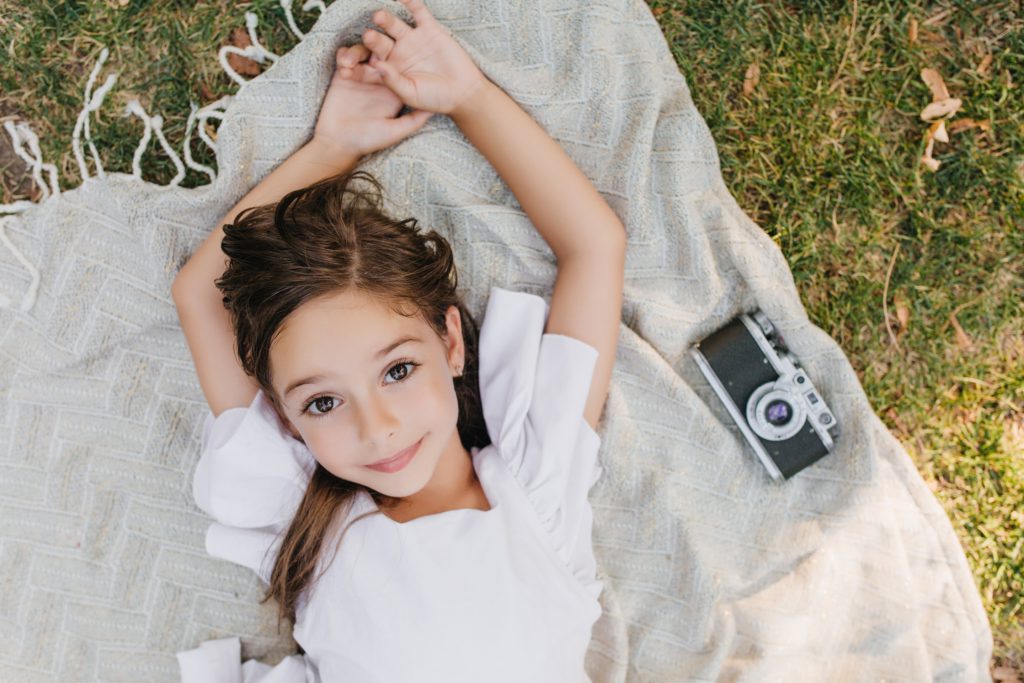 A young woman lies on the grass.