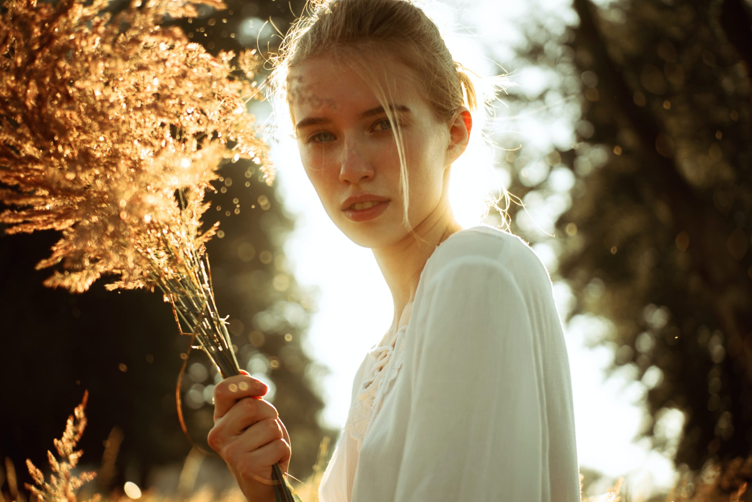 A girl in a garden holding a bouquet of yellow flowers