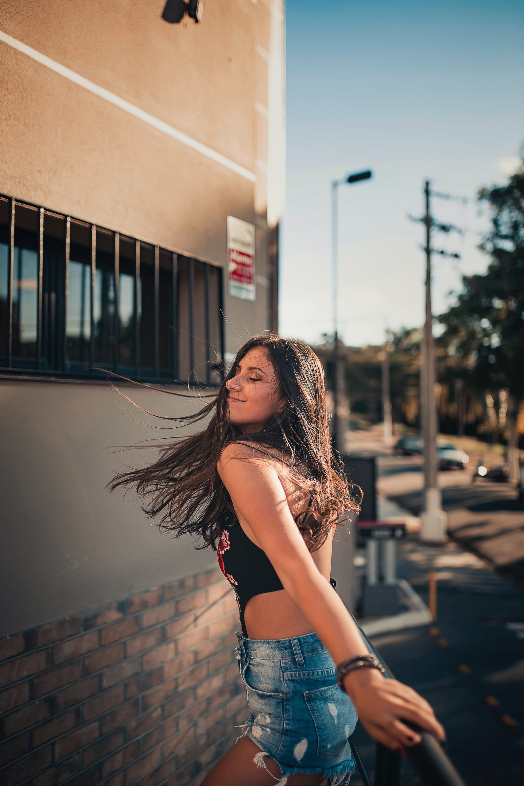 Girl in jeans and top leaning and holding a handrail