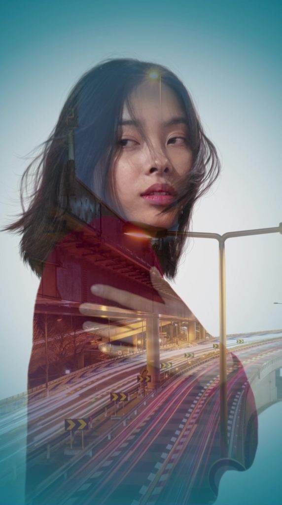 An image with a double exposure that combines a young woman and a highway.